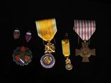 several medals are displayed on a black surface in a dark room