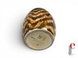 a brown and white vase sitting on a white surface