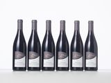 six bottles of wine are lined up on a table