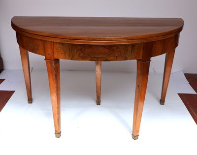 une table en bois au plateau incurvé, posée sur un sol en damier