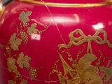 a large red vase with gold decoration on it