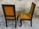 two chairs sitting next to each other on a cobblestone floor