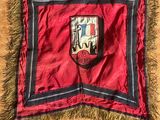 une image représentant un drapeau rouge et noir orné d'un blason