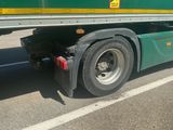 a green and yellow semi truck parked on the side of the road