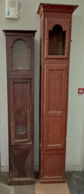 two tall wooden clocks next to each other in a room