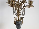 a gold and black candelab with a vase on top of it
