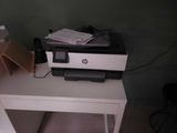 a printer sitting on top of a small white table