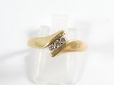bague en or jaune sertie de deux diamants sur une surface lisse
