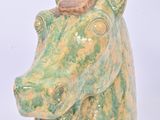 a green and yellow horse head vase on a white background