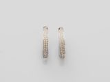a pair of white gold hoop earrings on a white background