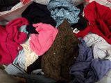 a suitcase full of clothes that is sitting on a bed
