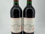 deux bouteilles de vin rouge posées l'une à côté de l'autre sur une surface blanche