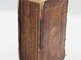 a close up of an old book on a white surface