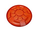 an orange plastic plate with circles on it on a white background