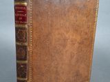 un livre ancien avec une couverture en cuir marron et des bordures dorées