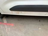 a white car that has a red line on the side of the road