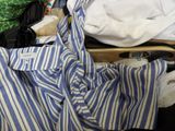 a blue and white striped shirt sitting on top of a piece of luggage