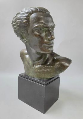 un buste en bronze représentant une femme, posé sur un socle noir