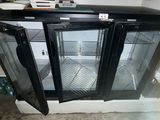 a refrigerator with two glass doors open in a kitchen