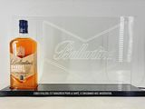 the bottle of ballant ' s bourbon sits next to a glass plaque