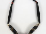 a close up of a necklace on a white surface