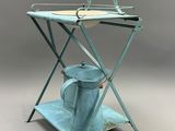 une petite table sur laquelle se trouvent une théière et un arrosoir