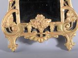 a gold frame with a mirror on it on a table