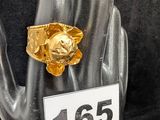 une bague en or sur laquelle est représenté un lion assis sur une main