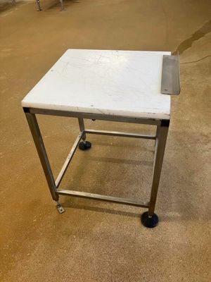 une petite table blanche à roulettes posée au sol