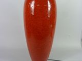 un vase rouge posé à côté d'une lampe