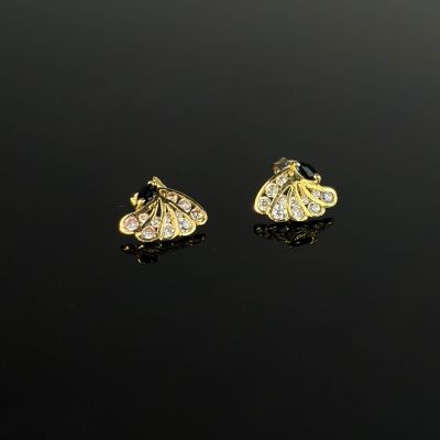 une paire de boucles d'oreilles en or et diamants sur une surface noire