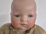 a baby doll that is sitting on a white surface