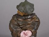 figurine of a man sitting on a stool with a sign on his chest