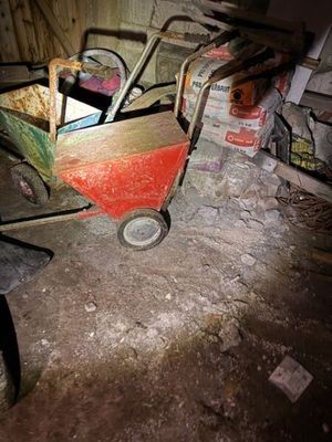 un petit chariot rouge posé au milieu d'une pièce sale
