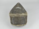 an old silver mesh box with a metal handle on a white surface
