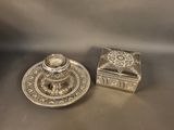 two silverplated candlesticks and a box on a table