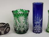 plusieurs vases en verre de différentes couleurs sont alignés sur une surface blanche