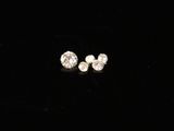 a pair of diamond stud earrings on a black background