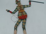 une figurine en bois représentant une femme tenant un bâton