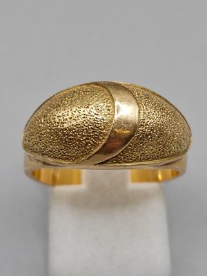 a close up of a gold ring on a white surface