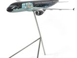 une maquette d'avion posée sur un socle, sur une surface blanche