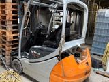 un chariot élévateur garé à côté d'une pile de palettes