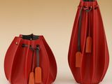 une paire de vases en cuir rouge ornés d'étiquettes, sur fond beige
