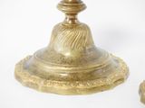a gold candle holder with a candle on top of it
