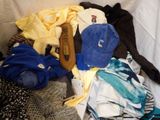 a pile of clothes that is sitting on a bed