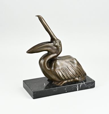 une statue en bronze représentant un pélican posé sur un socle en marbre