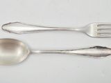 two spoons and a fork on a white table