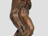 a bronze statue of a man sitting on top of a wooden base