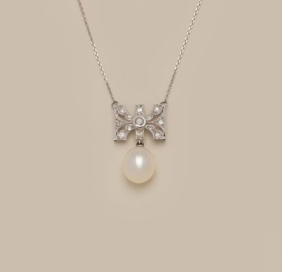 a white pearl and diamond pendant on a silver chain