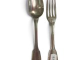two silver spoons and a fork on a white surface
